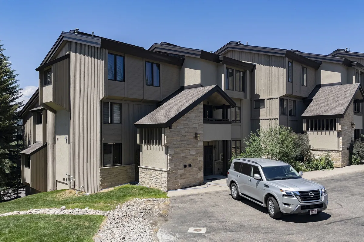 This image shows the exterior of the property with modern architecture, a landscaped lawn, and a parked vehicle. The outdoor area appears inviting, with space for gatherings or quiet relaxation, and the bright natural light suggests a cheerful, welcoming atmosphere.